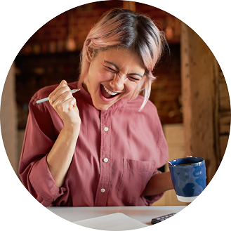 Women cheering while holding a pen and cup of coffee in her hand.