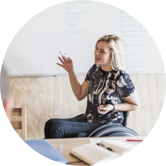 Woman in wheelchair presenting a topic to coworkers.