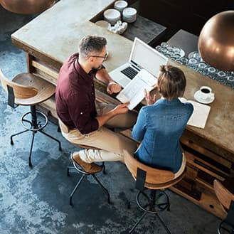 Coworkers reviewing a document at a restaurant desk.